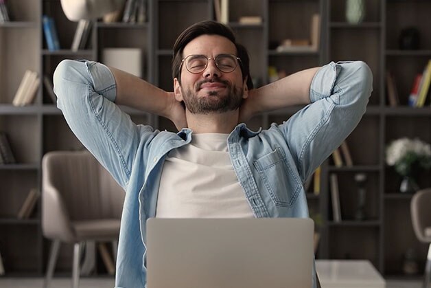 Hombre estirandose frente al computador