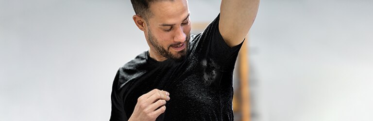 Joven con mancha de sudor en la ropa