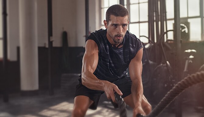 Joven atlético haciendo algunos ejercicios de fitness con una cuerda