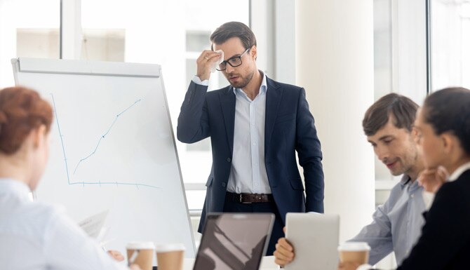 Hombre oficinista limpiándose el sudor frío de la frente