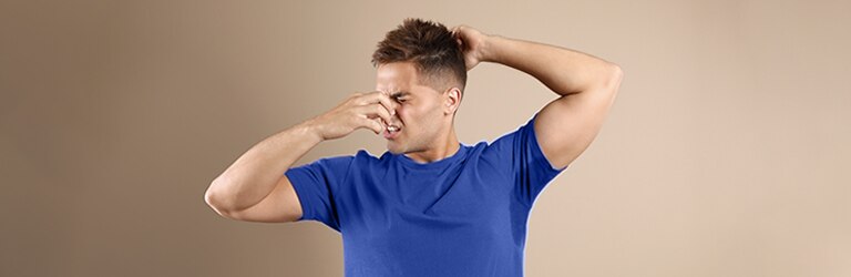 Joven con mancha de sudor en la ropa