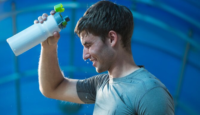 Hombre atlético sudado refrescándose tras ejercitarse