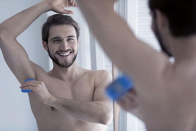 Hombre aplicandose desodorante